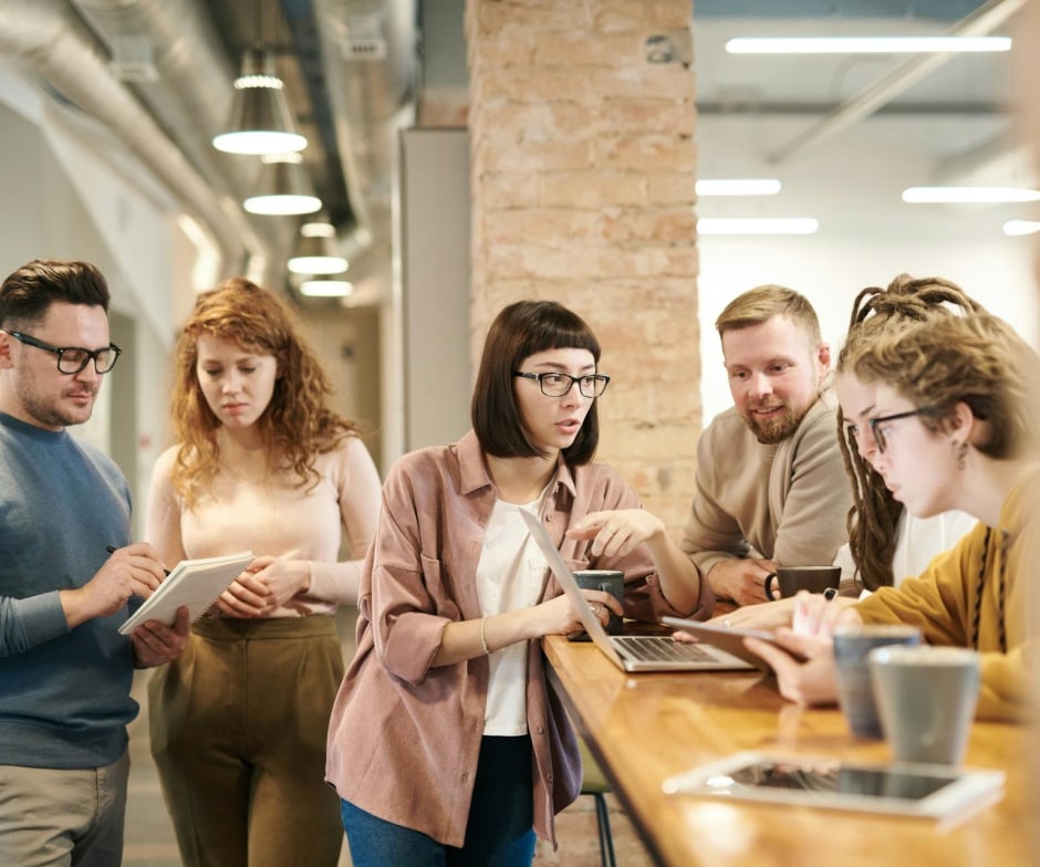 group gathered at a work station working together