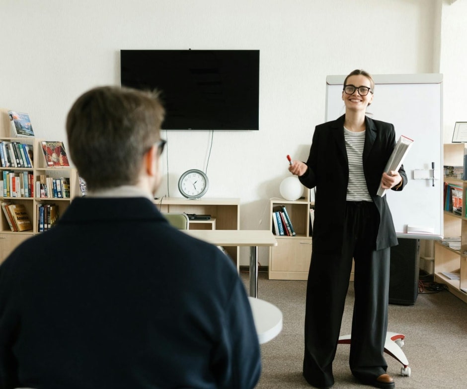 personal in suit explaining to person sitting on chair