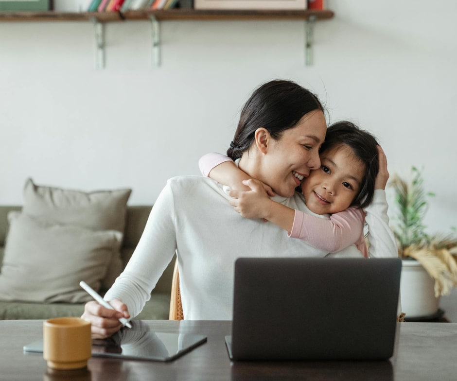kid hugging parent while parent working