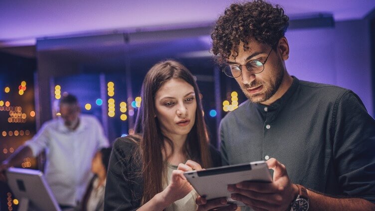Deux personnes regardent une tablette