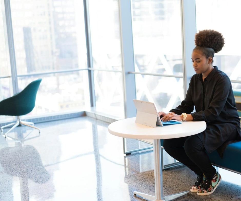 person sitting on table chair and working