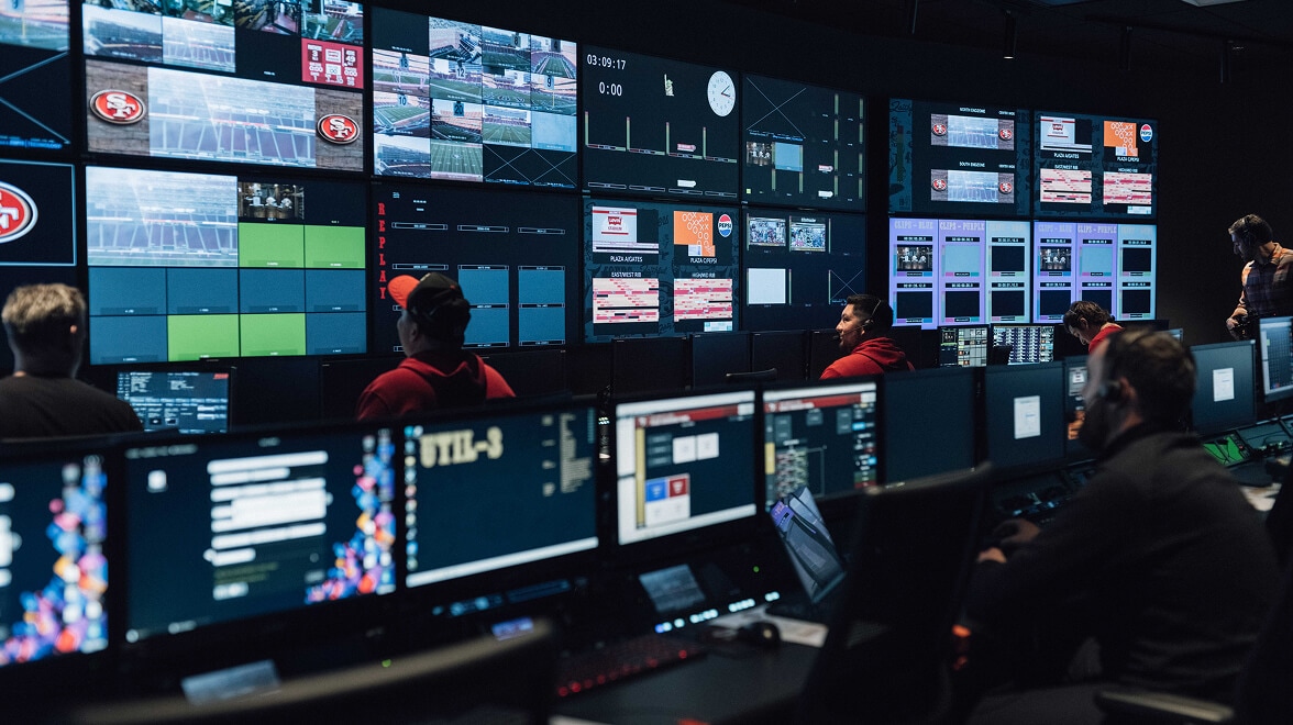 Salle de contrôle de diffusion où le personnel gère les flux vidéo en direct et la production du stade pour un événement des San Francisco 49ers.