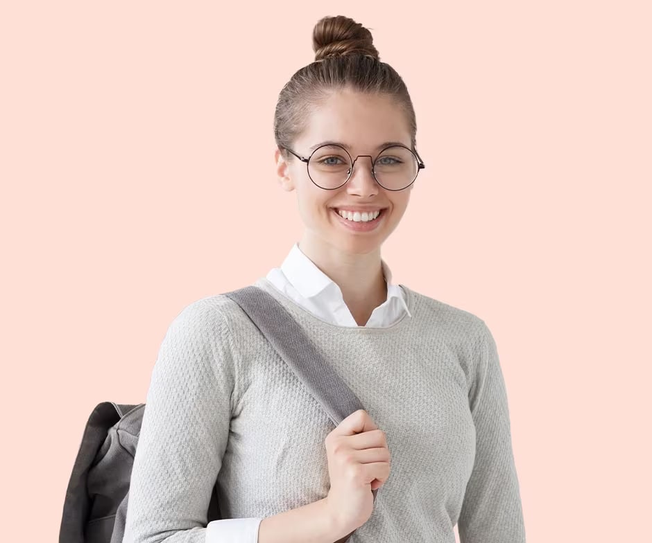 Donna con chignon e occhiali rotondi che sorride, con uno zaino sulla spalla e una mano che tiene la tracolla dello zaino.