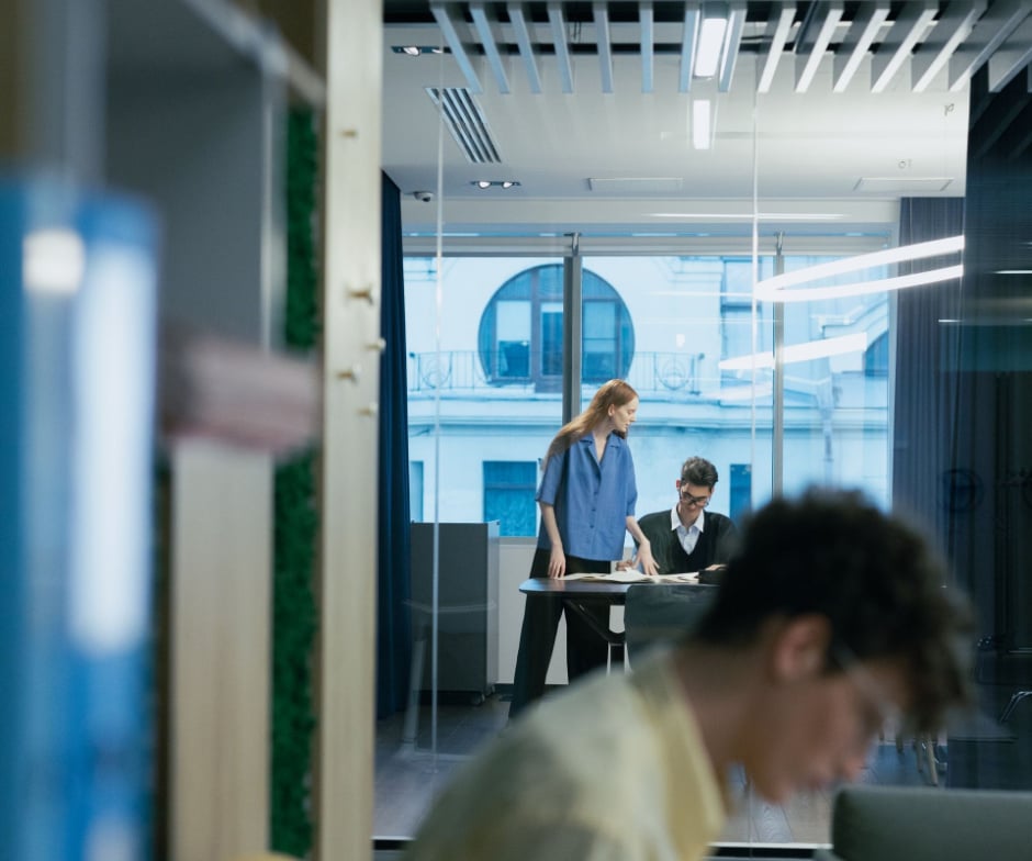 Moderner Büroarbeitsplatz, in dem Fachleute in einem gläsernen Besprechungsraum zusammenarbeiten – ein Zeichen für Teamarbeit, Produktivität und Geschäftskommunikation.