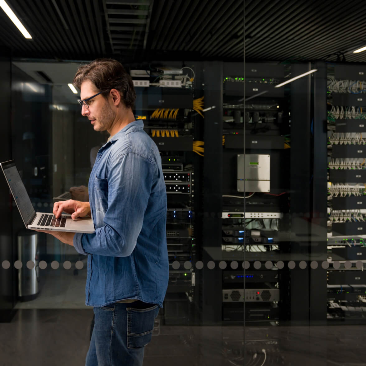 pessoa segurando laptop anad andando no data center