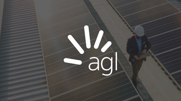 AGI logo over a worker walking with a laptop between solar panel rows