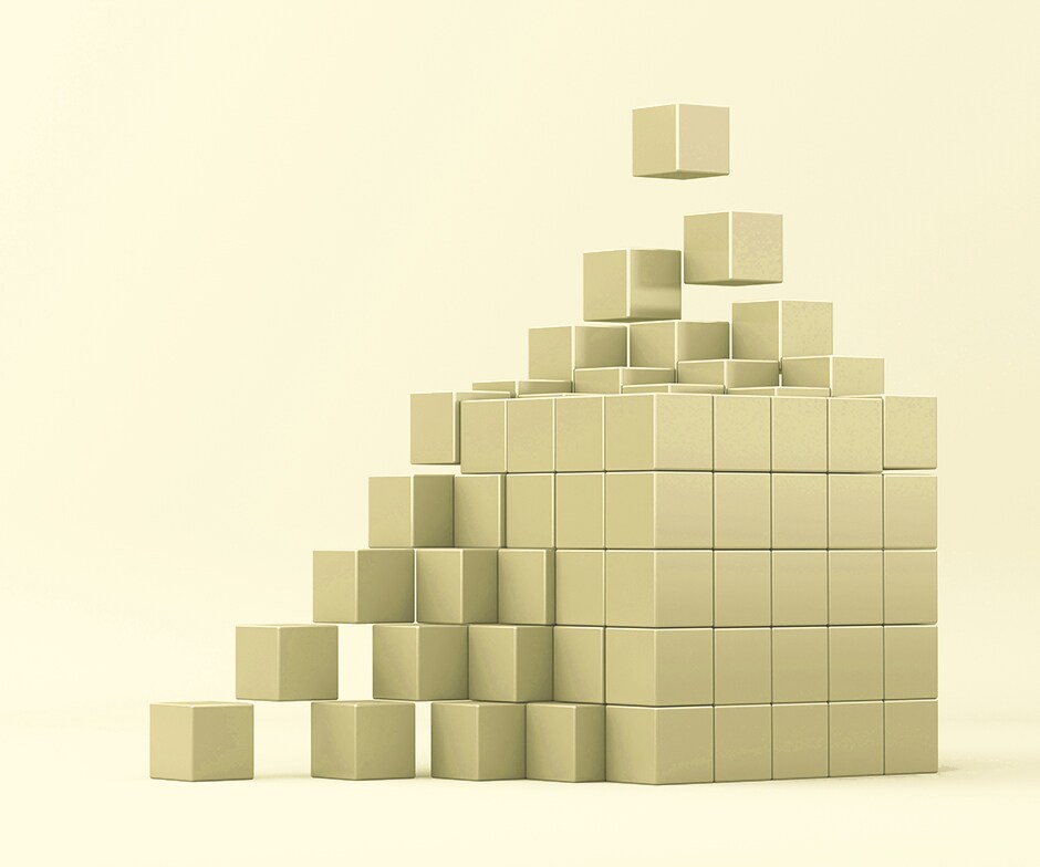soft yellow background with small gold blocks coming together to form larger gold cube