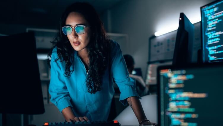 Una persona mirando el monitor en la oscuridad