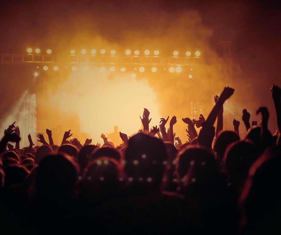 a crowd at a concert with their hands up