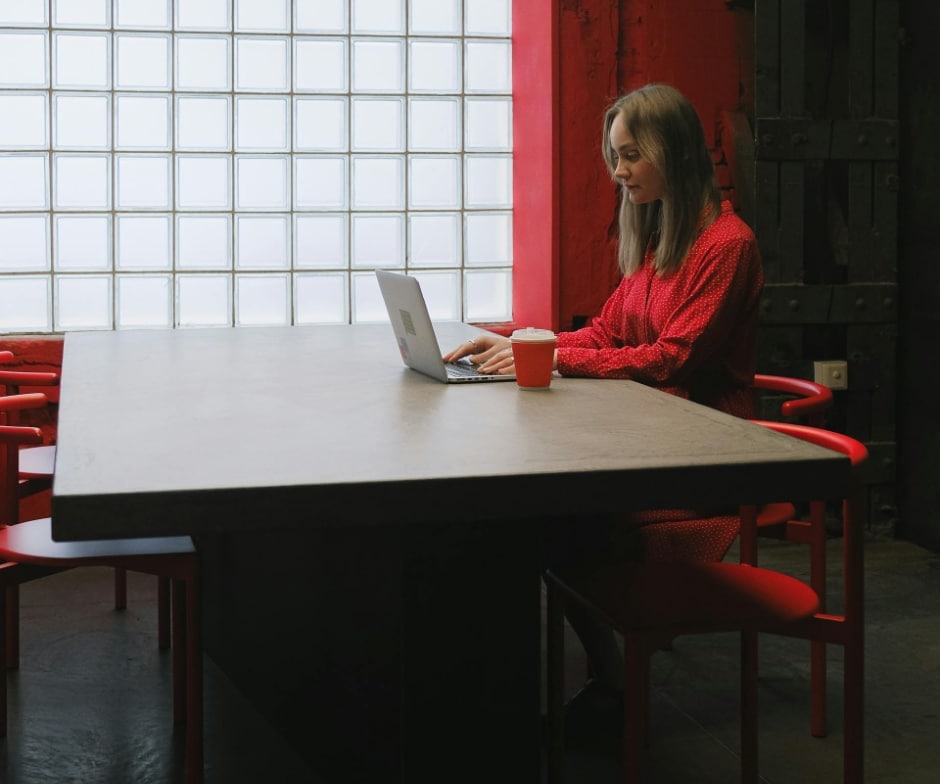 person in red unifrm sitting in a room with table and a coffe