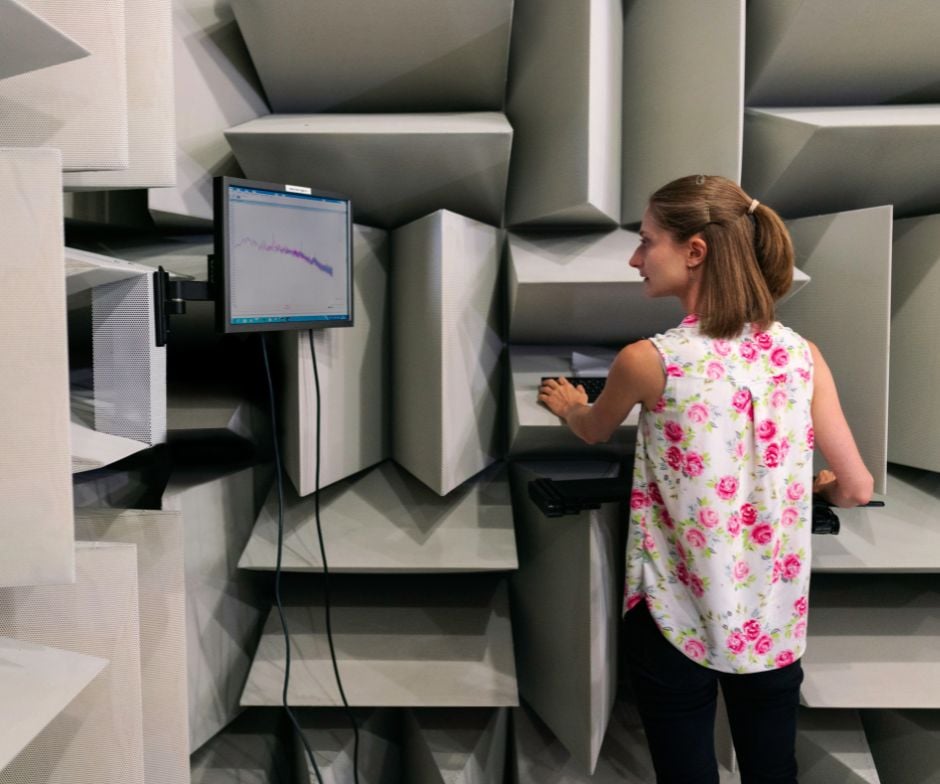 women standing at looking at graph on a monitor