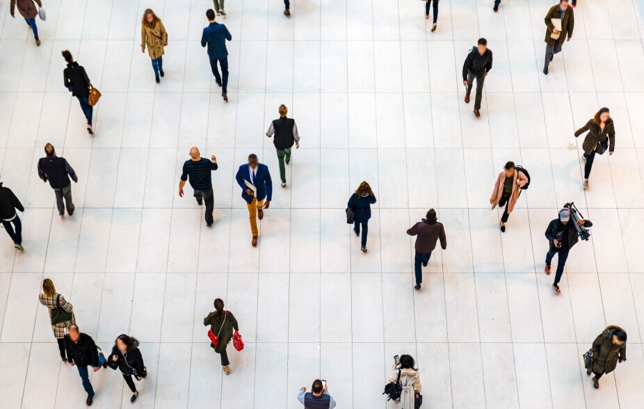 Birds’ eye view of a group of people walking on a tile floor.