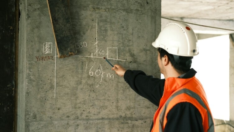 Construction worker working an equation