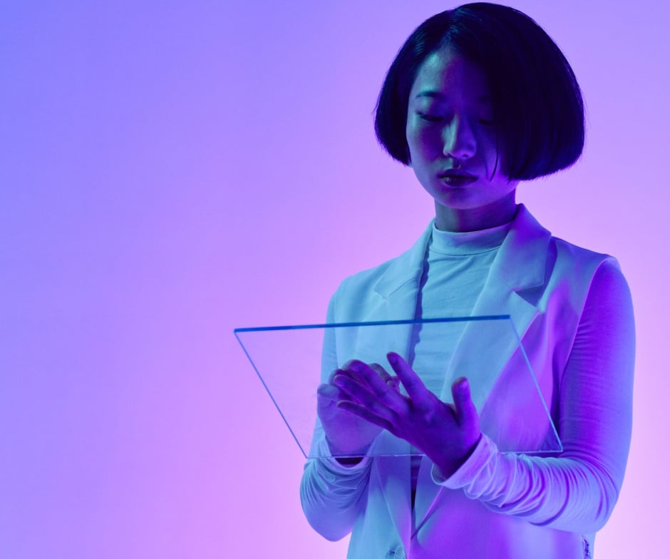 Person using a transparent digital interface in a purple and blue futuristic setting.