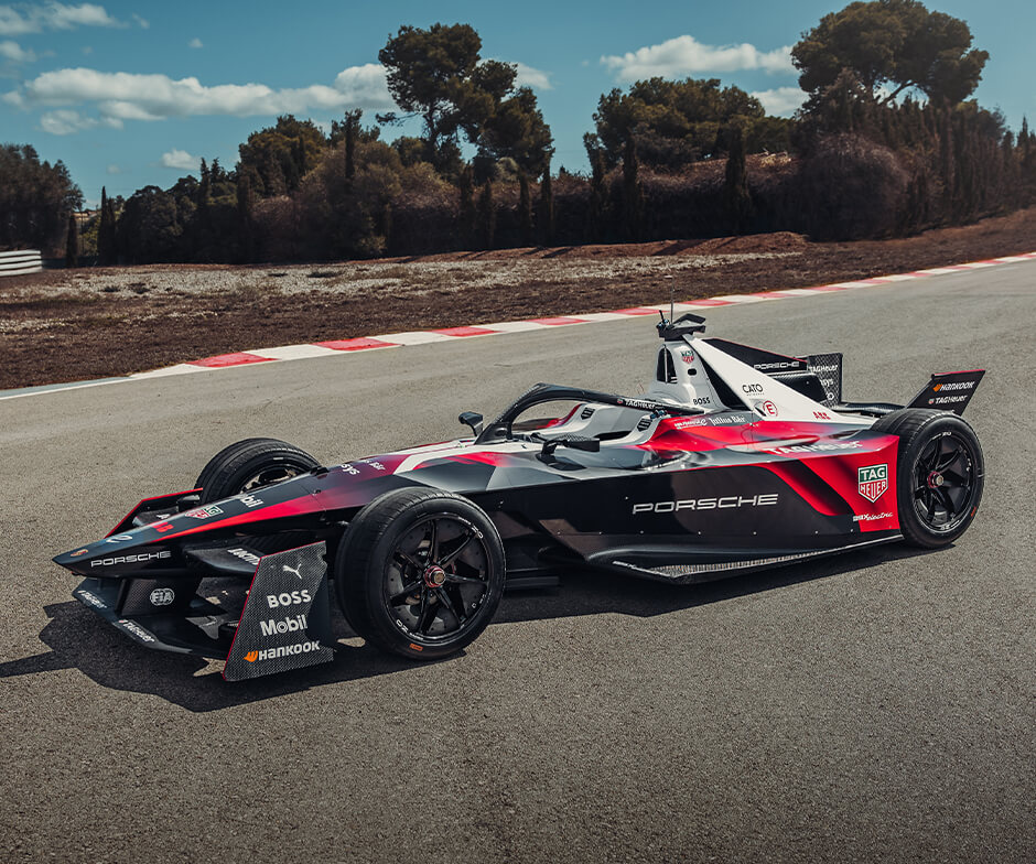 Vista lateral del coche de TAG Heuer Porche Formula E, al aire libre, parado en una pista.