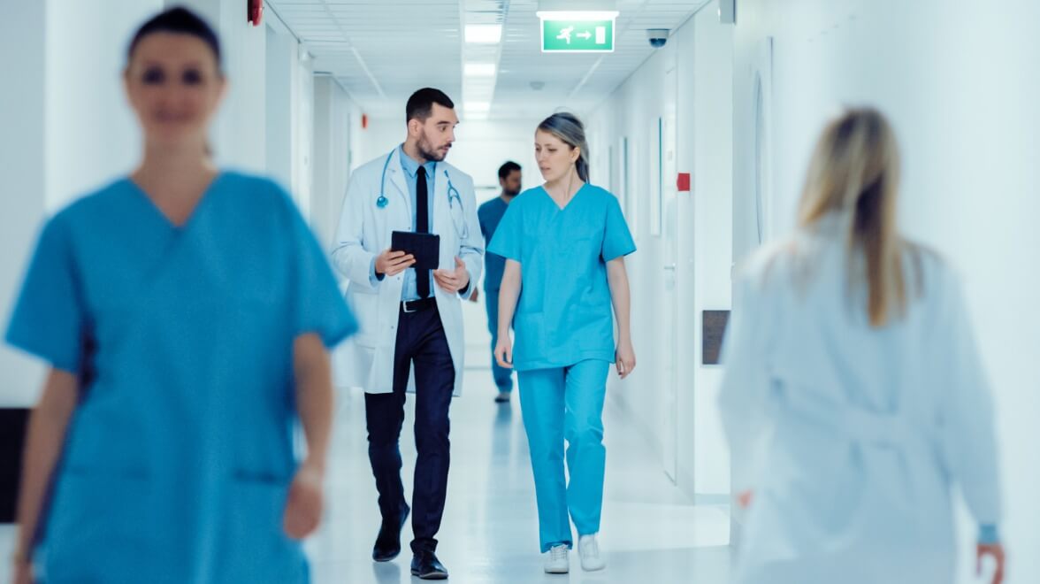 médicos caminando por el pasillo mientras discuten
