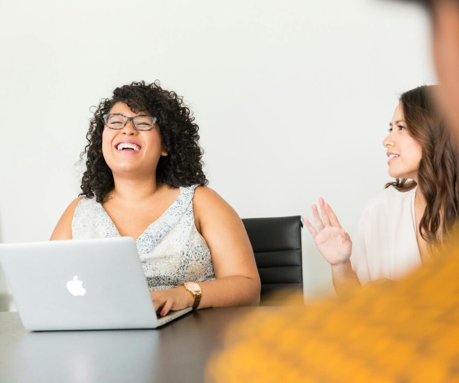 people sitting in conference room talking and laughing
