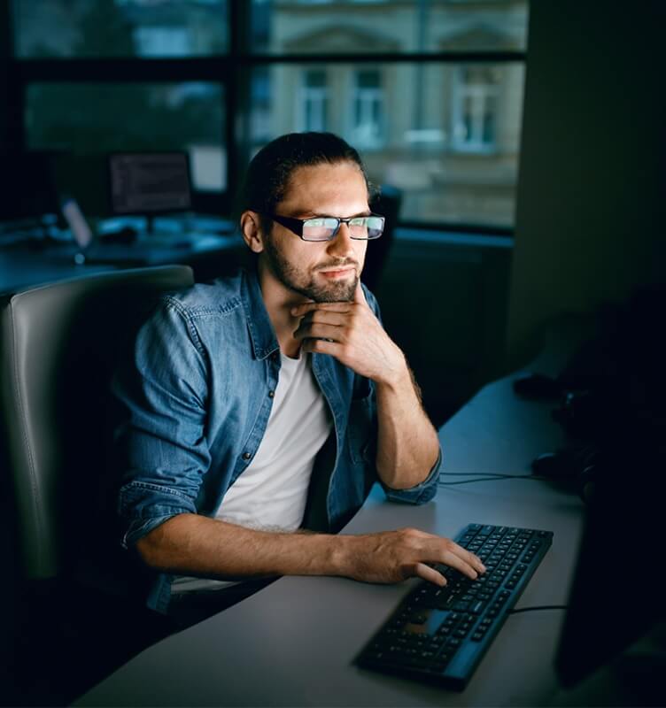 Man working at a desk in a darkened office