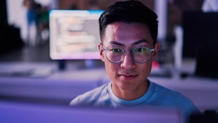 Vista más cercana de la cara de una persona que está mirando el monitor