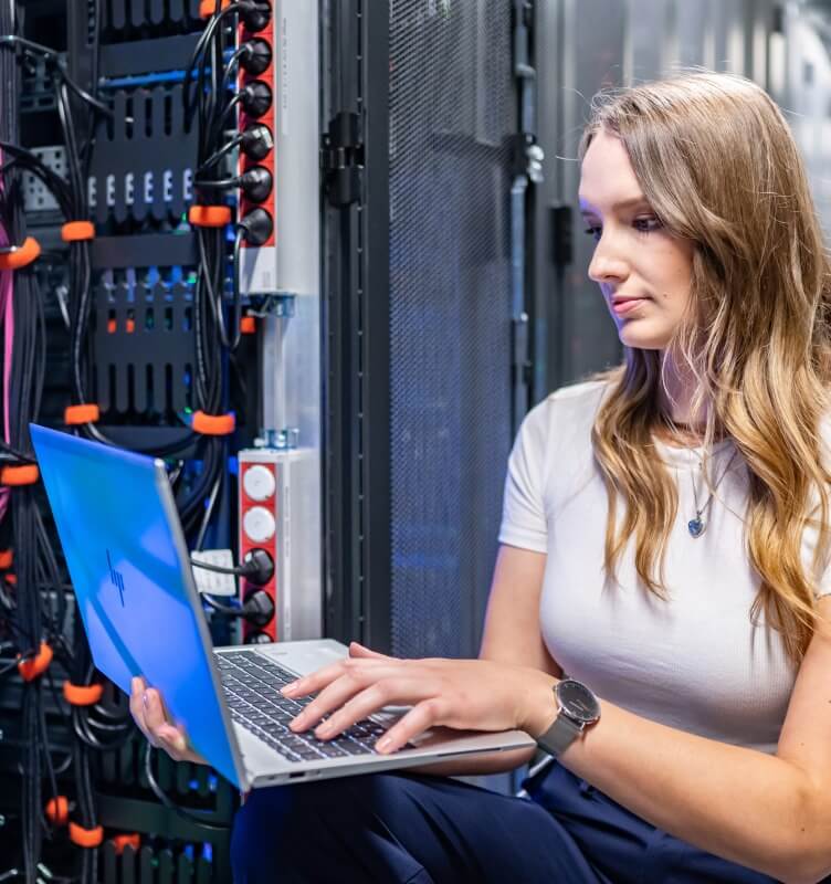 Woman with laptop in a data center