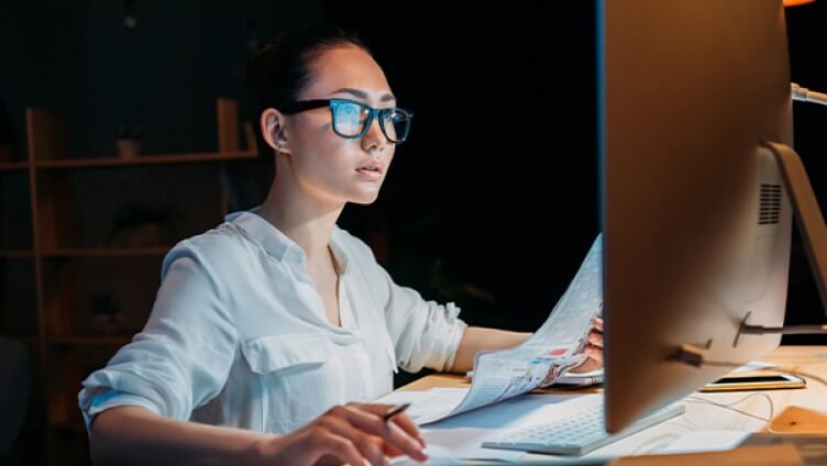 persona che indossa occhiali e lavora ai monitor