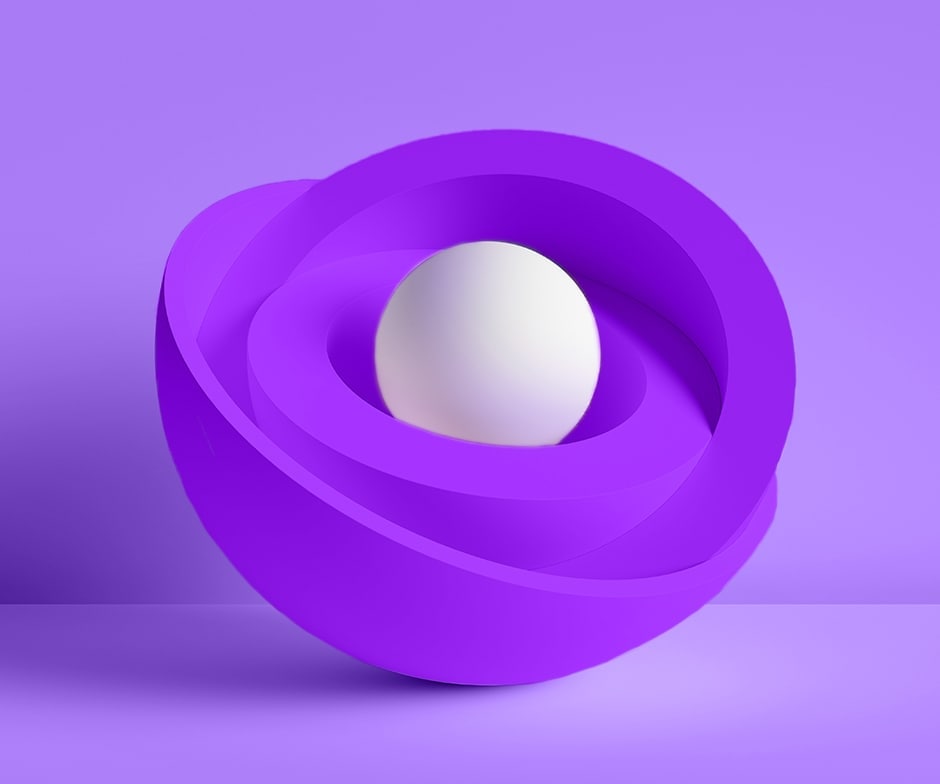 Fondo morado detrás de cuencos anidados morados con una esfera blanca en el medio