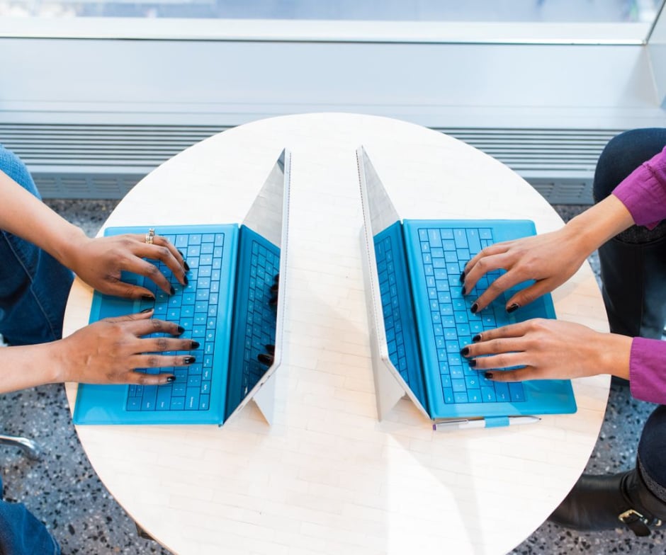 Hands typing on laptop