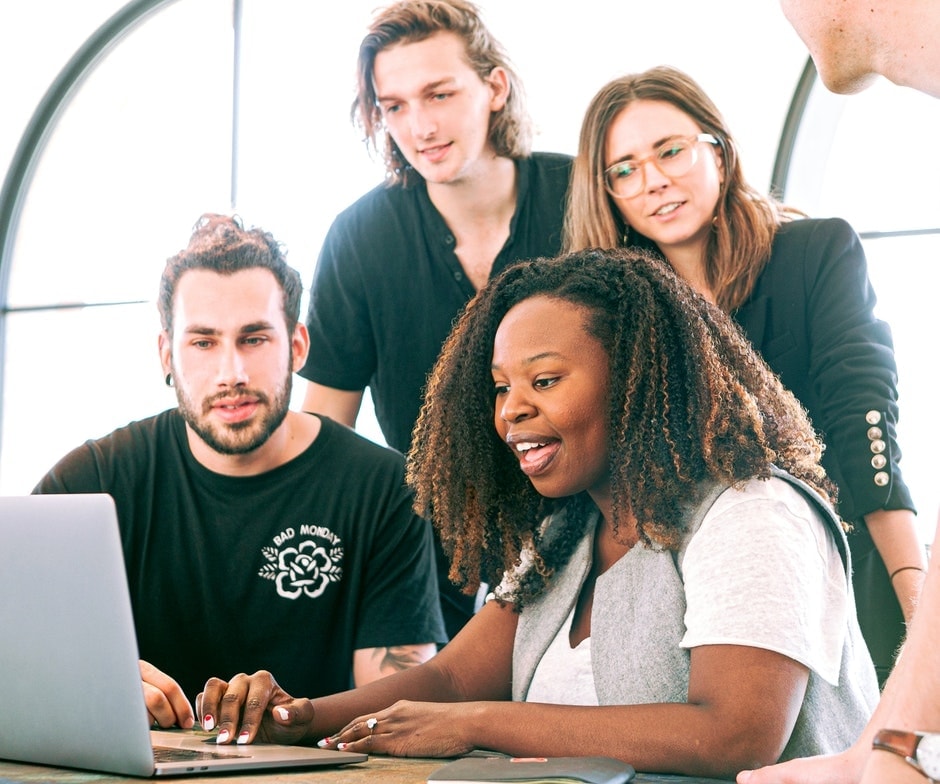 group of people working around a computer