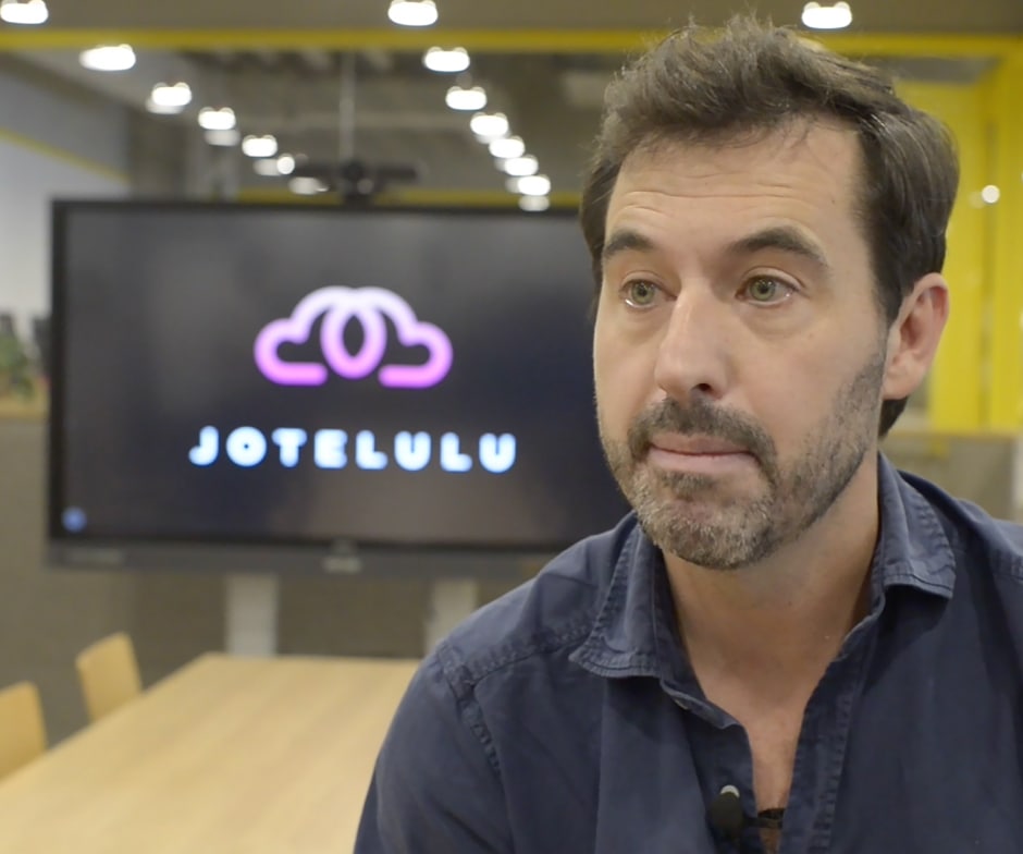 persona mirando hacia un lado con el logotipo de Jotelulu en la pantalla de fondo