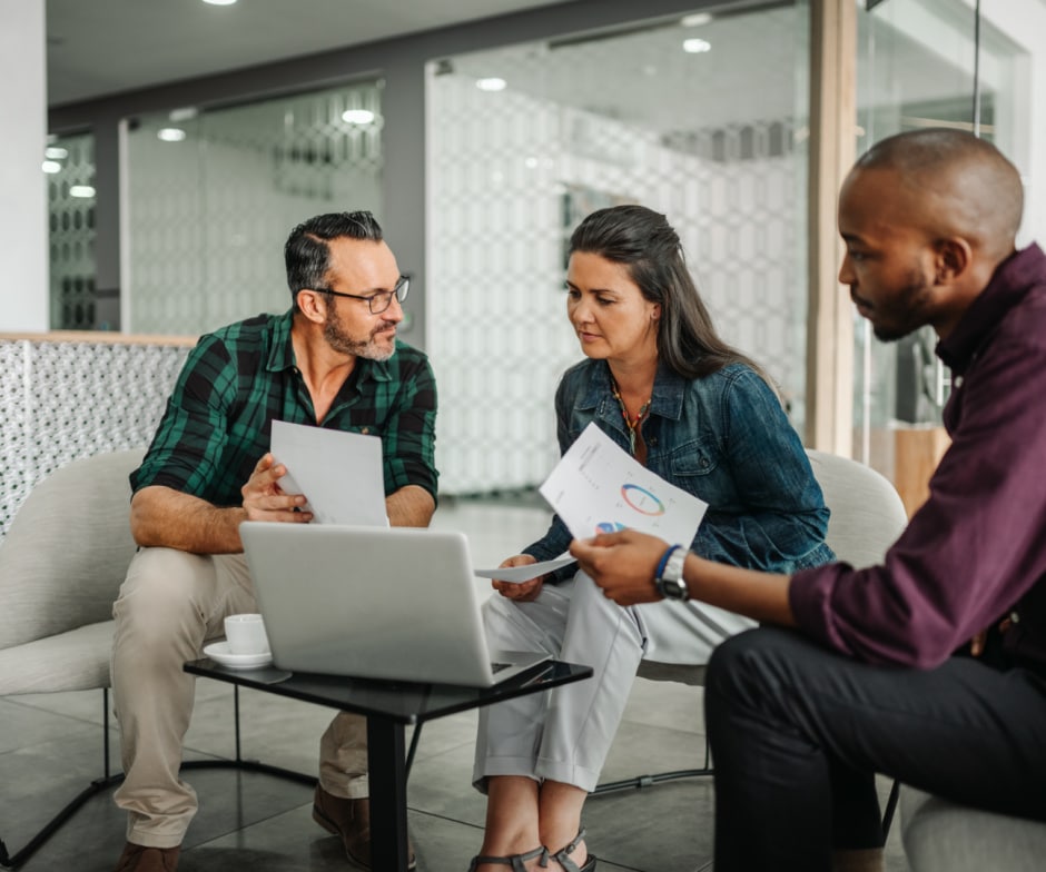 group of people sitting looking at data and analyzing
