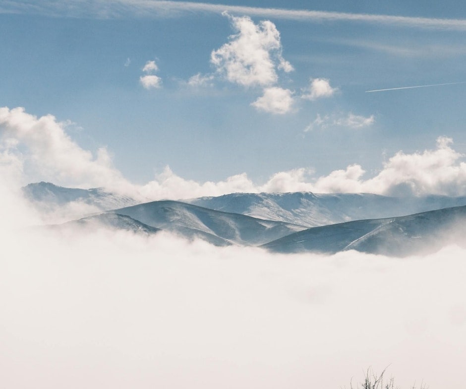view of mountains in middle of clouds