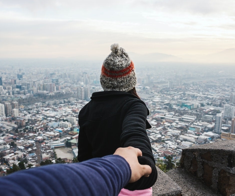 two people holding hands above a city
