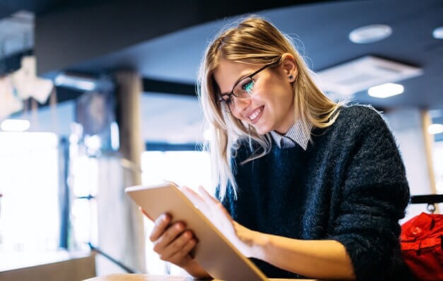 Pessoa com óculos escrevendo no bloco de notas