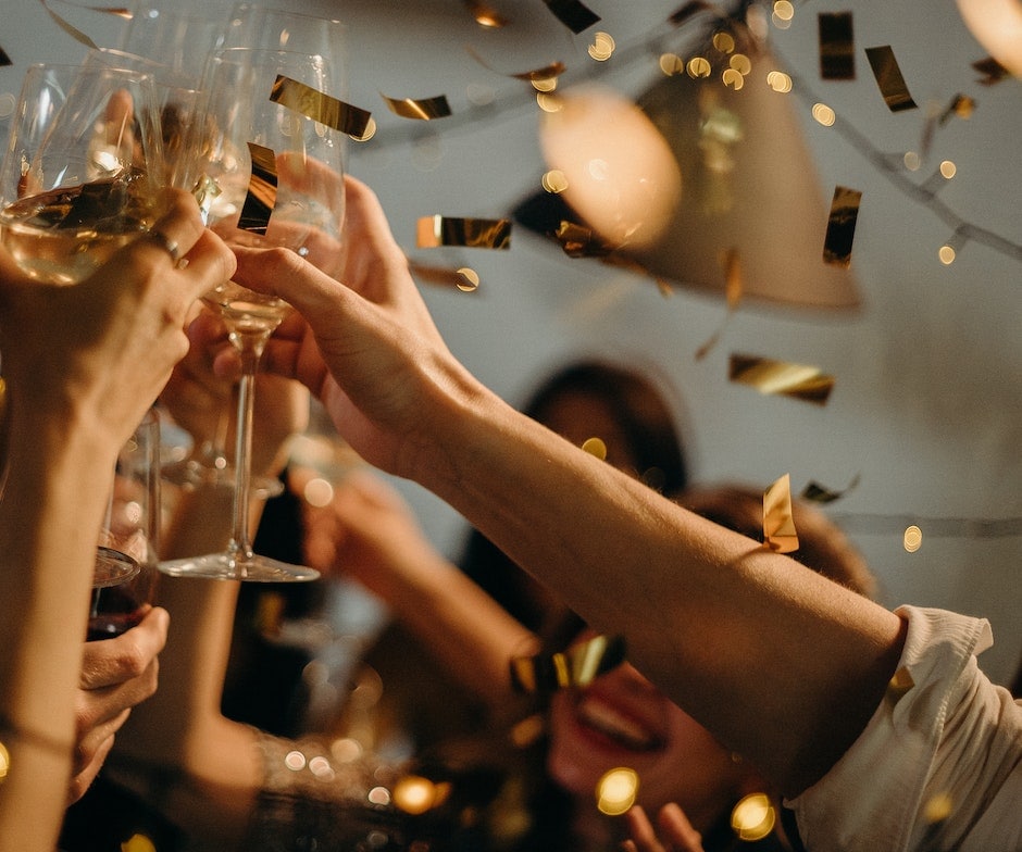 people cheering and congratulating by raising glasses