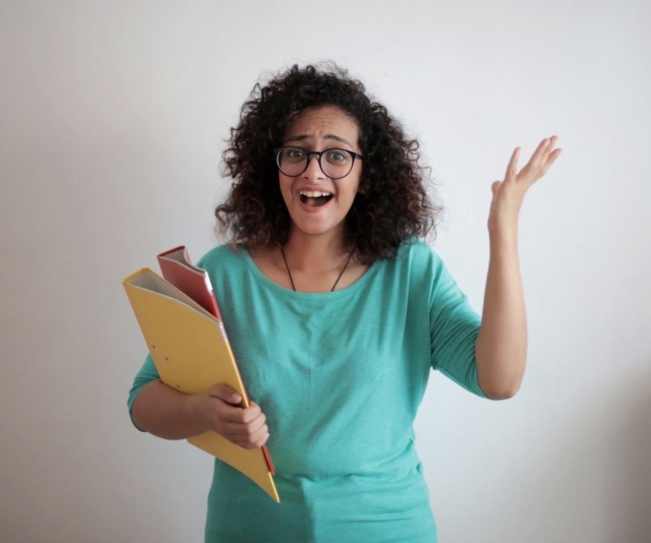 A person holding folders with her hand in the air