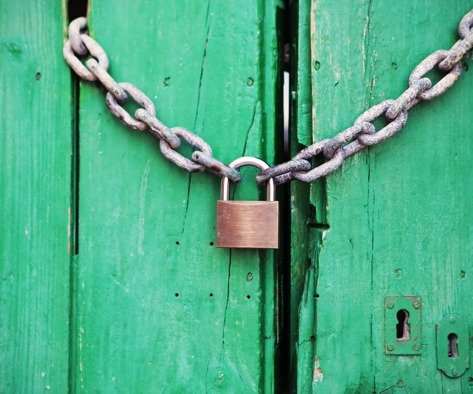 A lock on a green fence
