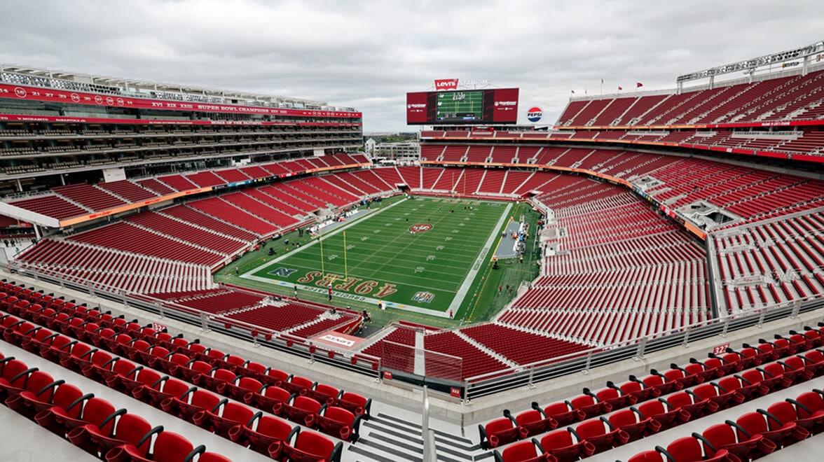 Stade de football américain des 49ers de San Francisco vide, avec des sièges rouges entourant un terrain vert, vu depuis les tribunes supérieures.