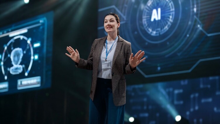 woman speaking with data on screens behind her