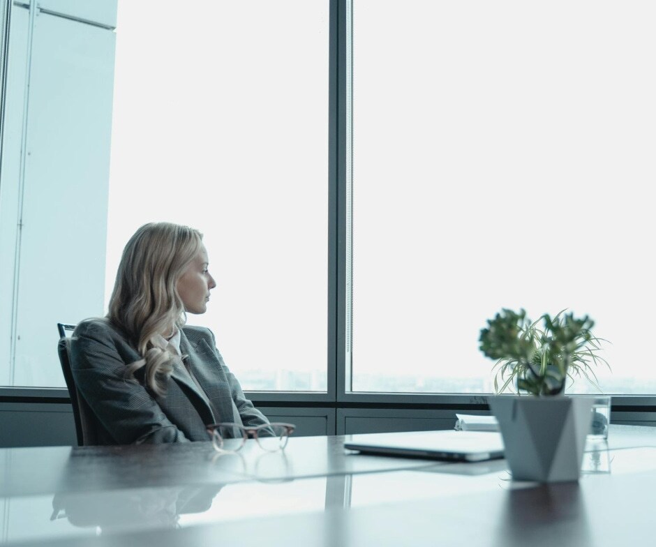 Woman sitting at table looking out the window