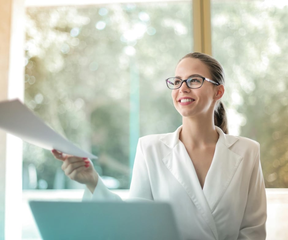 person in professional sui wearing glasses handing over documents