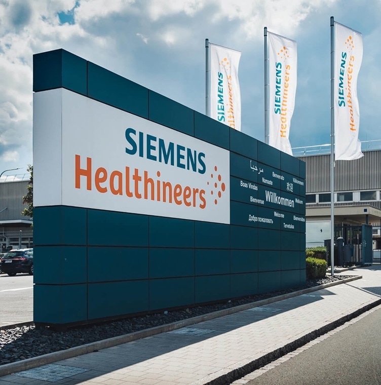 Siemens Healthineers facility entrance with company signage and flags displayed outside the building.