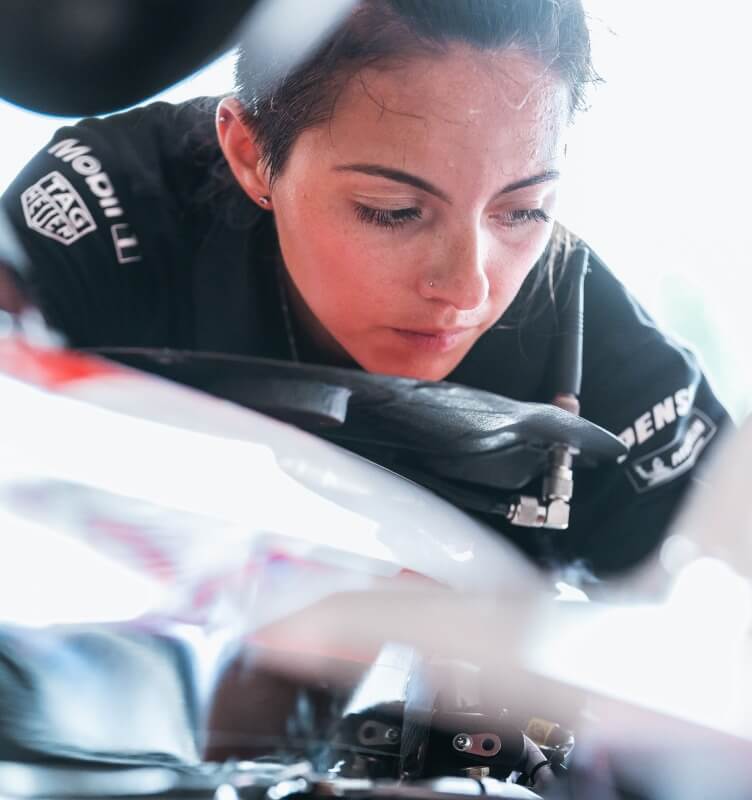 Porsche technician inspecting an engine