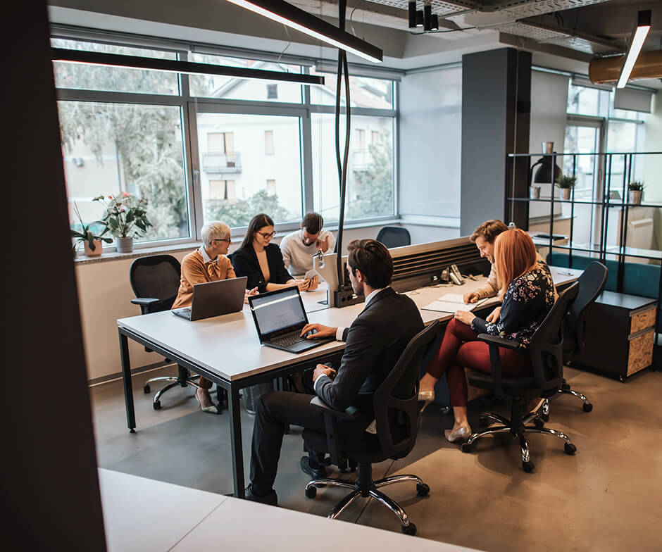 Six professionals at computers in modern office setting