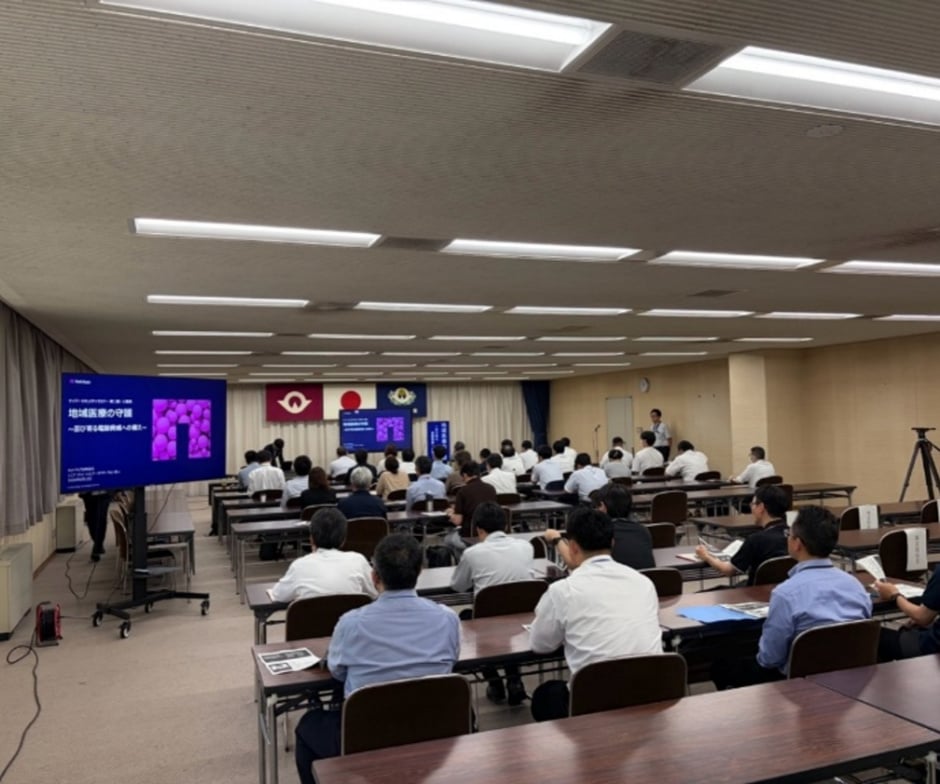 会議室で着席している警察官の聴衆に向けてプレゼンテーションが行われている。