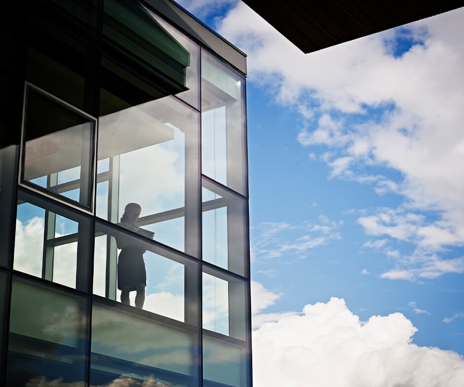 Una mujer mirando al cielo por la ventana de un edificio.