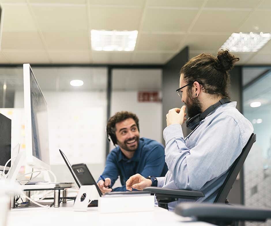 dois caras sentados e conversando na mesa de escritório