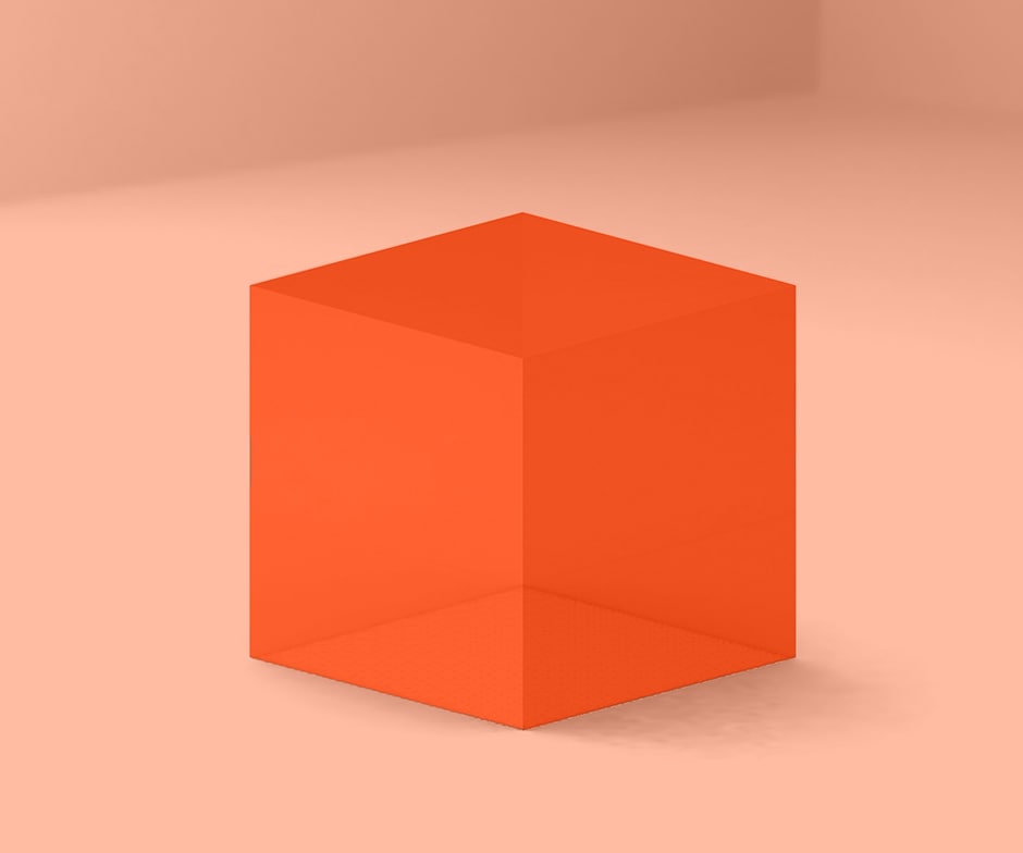 Orangefarbener Würfel vor pfirsichfarbenem Hintergrund