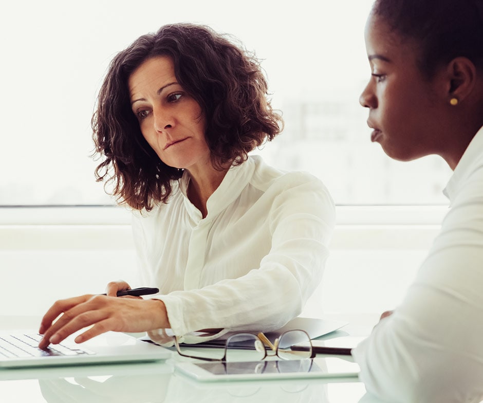 Zwei Frauen schauen gemeinsam auf einen Laptop