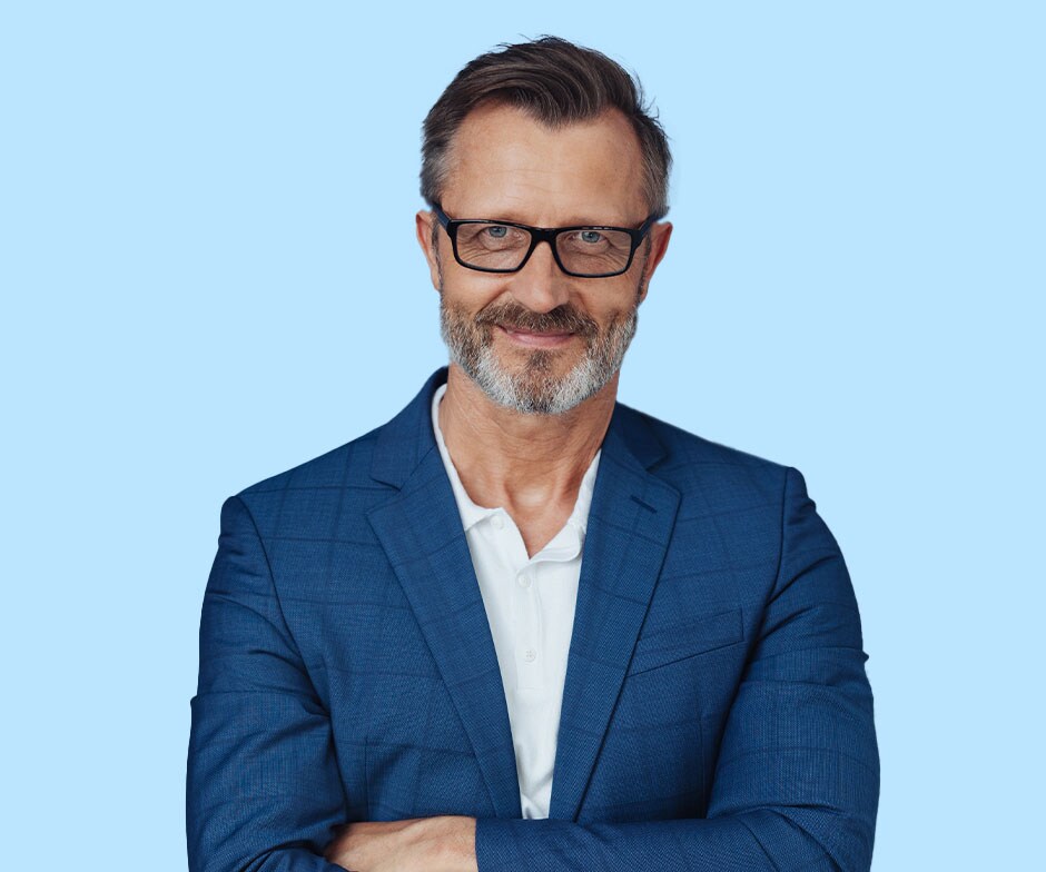 homme avec les bras croisés portant des lunettes et une veste bleue sur un polo blanc