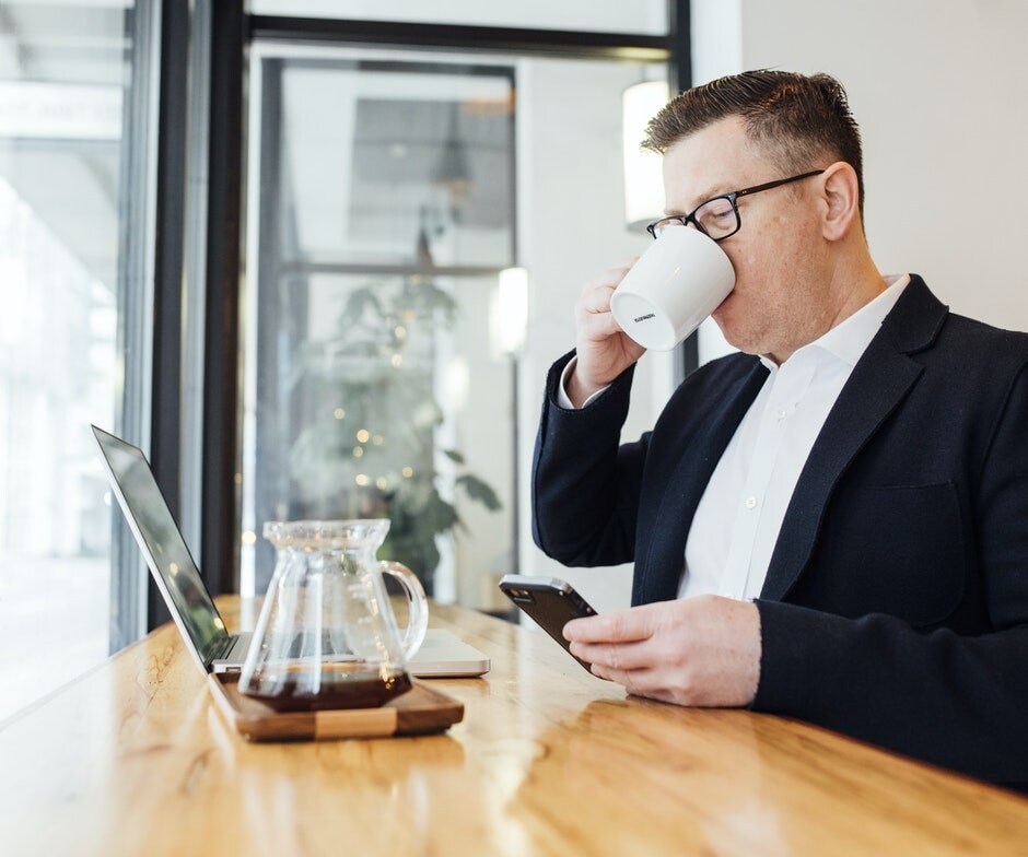 a man drinking coffee in a office
